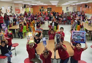 Students hold up the gifts they received during Texas Southmost College’s Angel Tree Toy Drive distribution on Dec. 16, 2015 at the Reynaldo Longoria Elementary School.